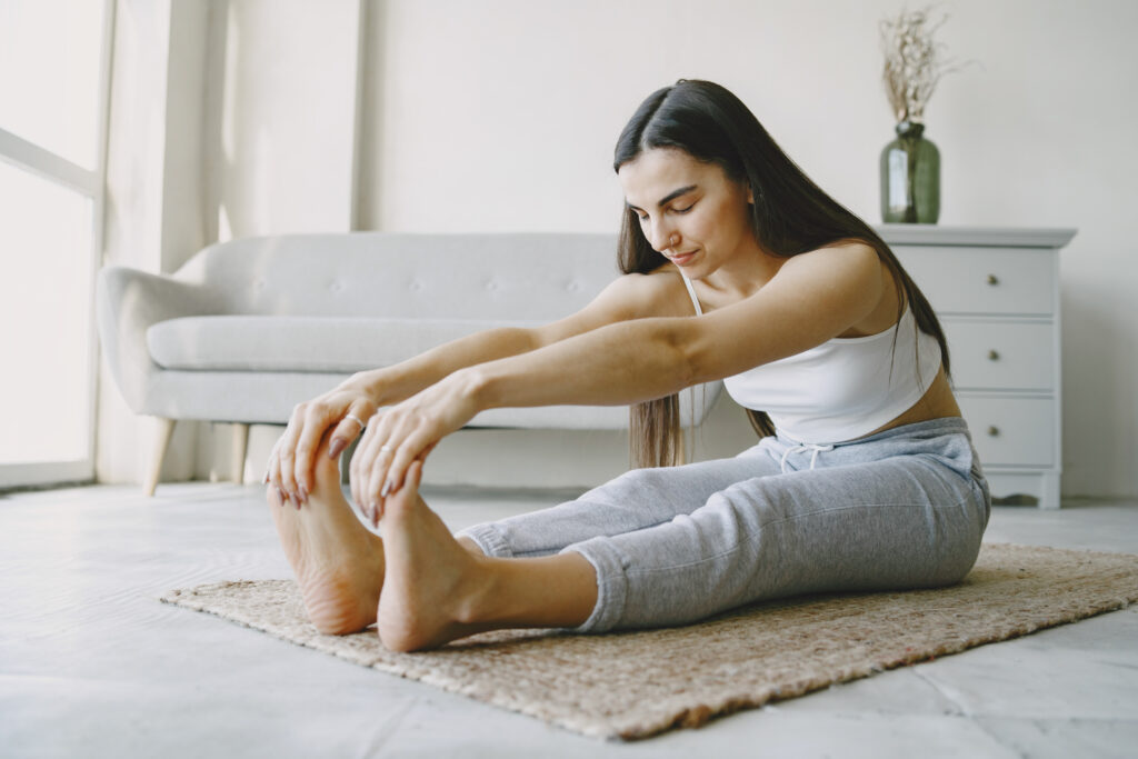 Mujer haciendo ejercicios de estiramiento para prevenir o aliviar metatarsalgia